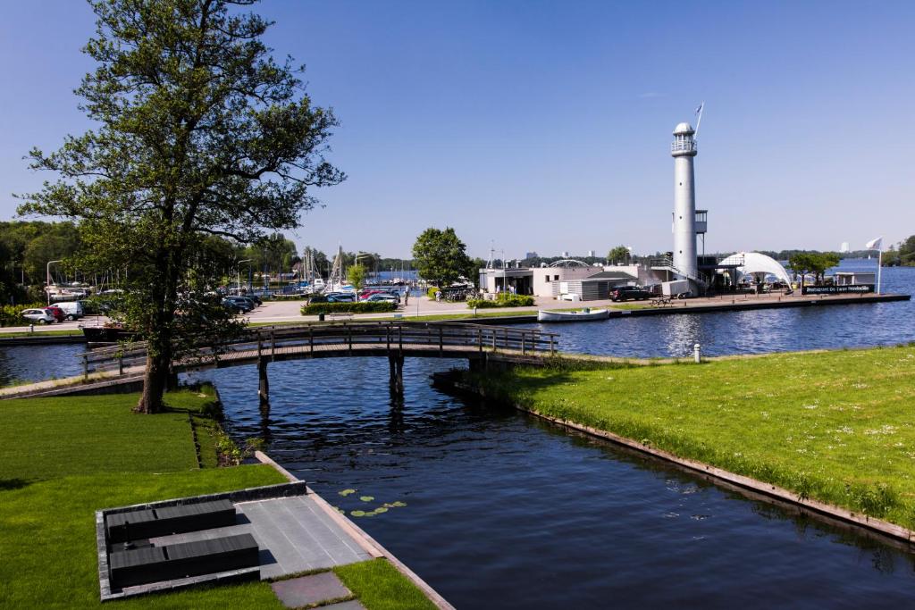 哈伦B&B Lisa Groningen的一座桥,在水体上,有一座灯塔
