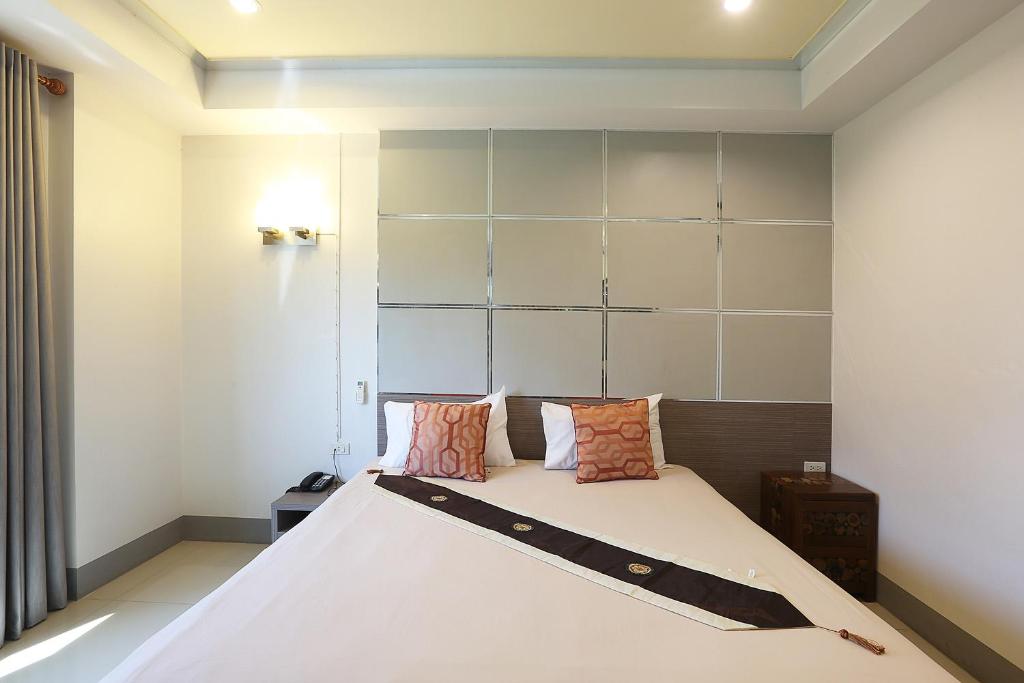 宋卡V公寓式酒店 的卧室配有带枕头的大型白色床