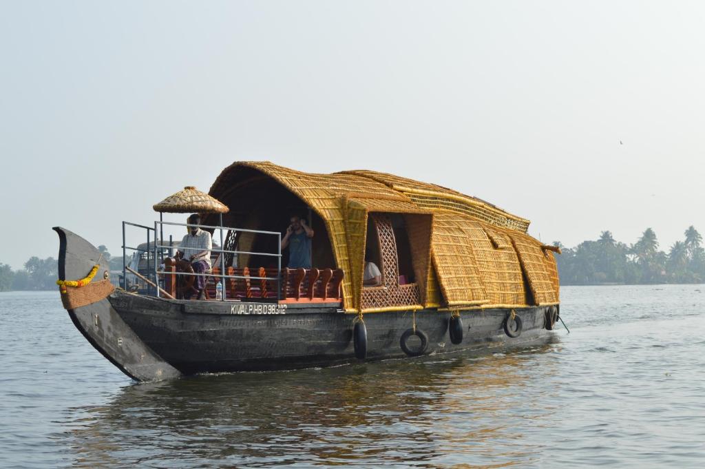 阿勒皮Thara's Houseboat的一条有稻草屋顶的船
