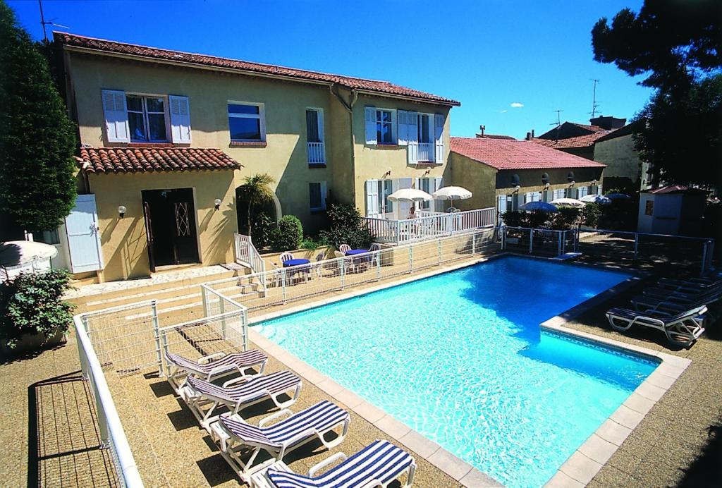 圣马克西姆卢宝乌瓦杜酒店的一个带躺椅的游泳池以及一座房子