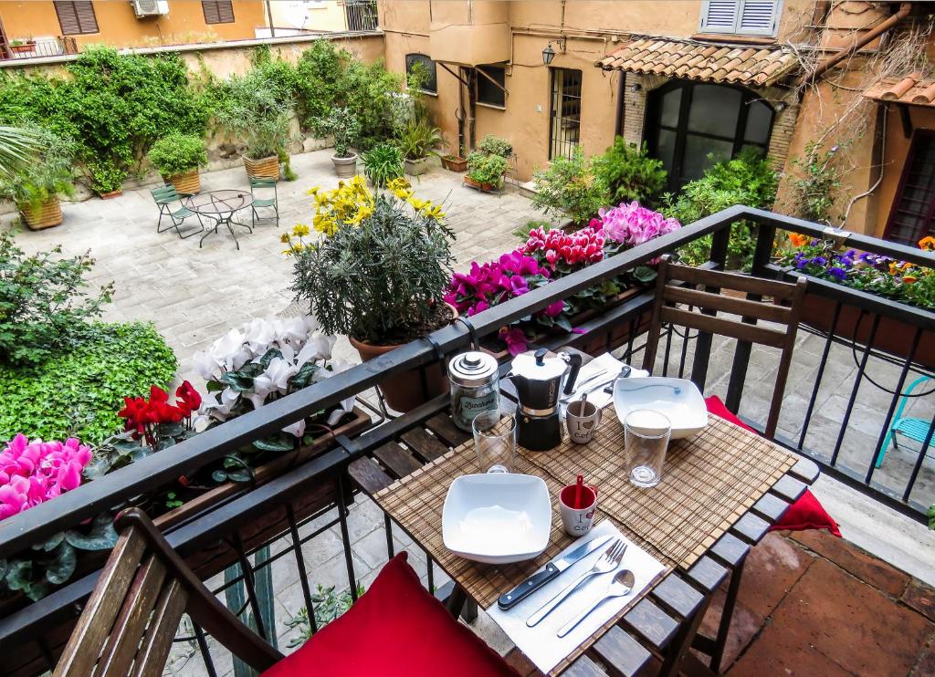 罗马Casa del Moro - romantic loft in Trastevere的阳台配有桌椅和鲜花。