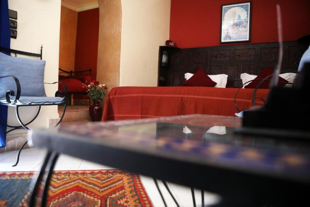 马拉喀什Riad Hotel Sherazade的客厅配有床和玻璃桌