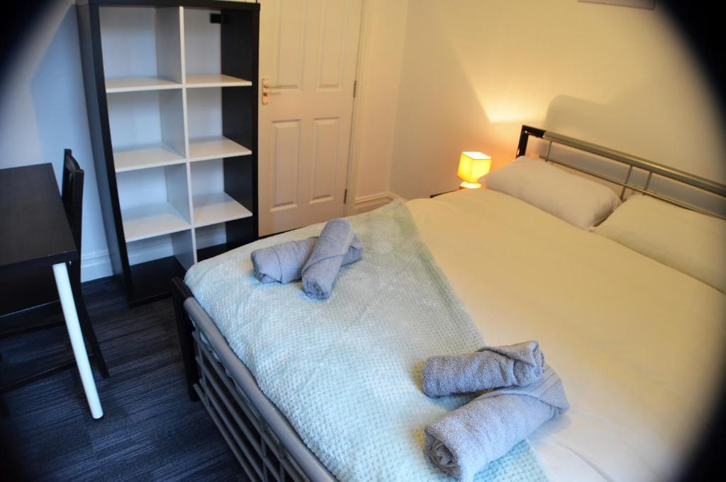 利物浦Old Swan Guest House的一间卧室配有一张床,上面有两条毛巾