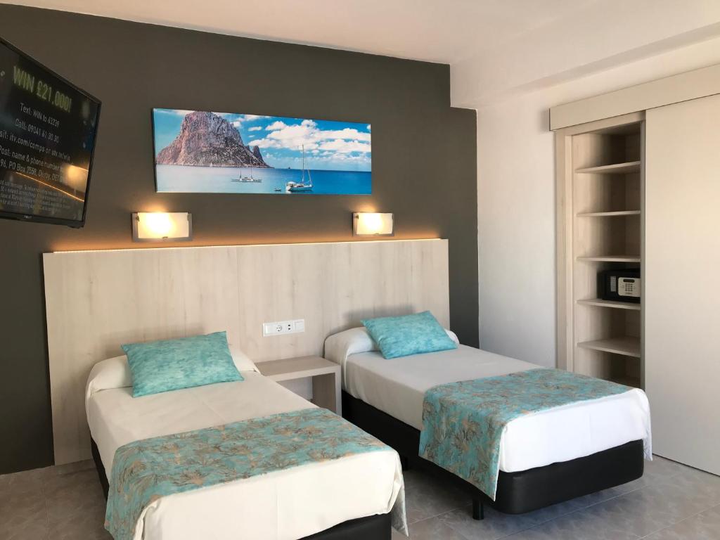 圣安东尼奥塞万堤斯旅馆的客房设有两张床和一台墙上的电视。