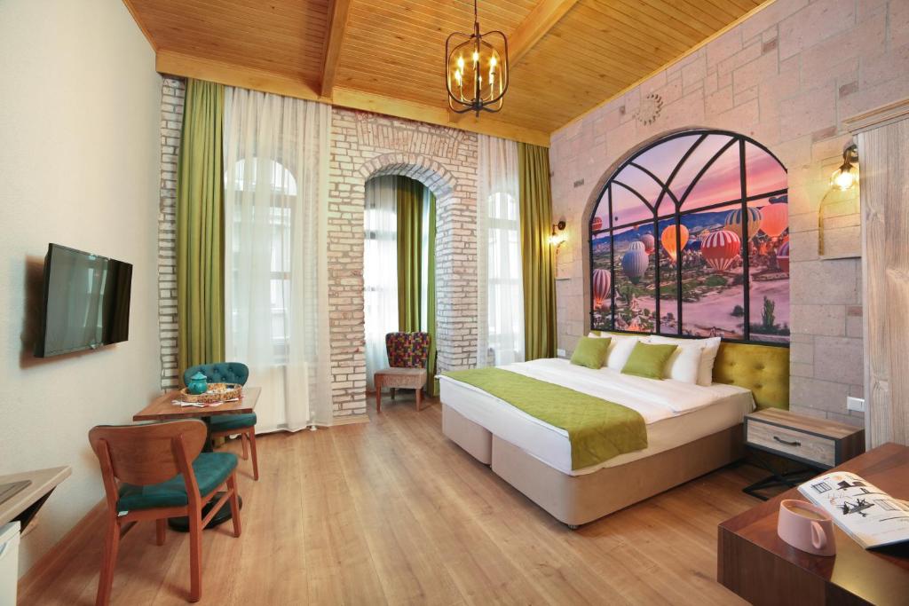 伊斯坦布尔Ardilas Residence的一间卧室配有一张床、一张书桌和一台电视。