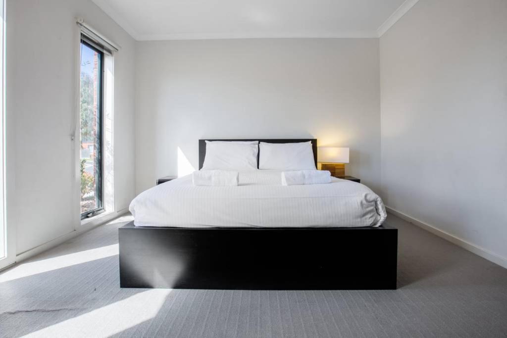 库克角Holiday Rose的白色卧室设有一张大床和两个窗户