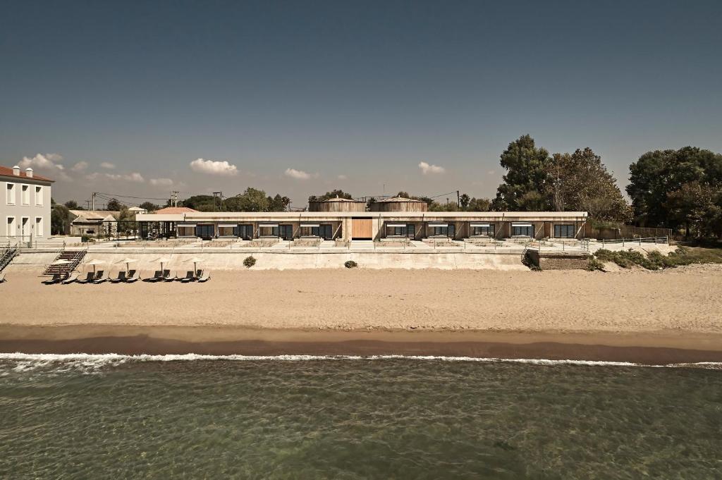 库鲁塔Dexamenes Seaside Hotel的海滩上摆放着椅子,建筑背景