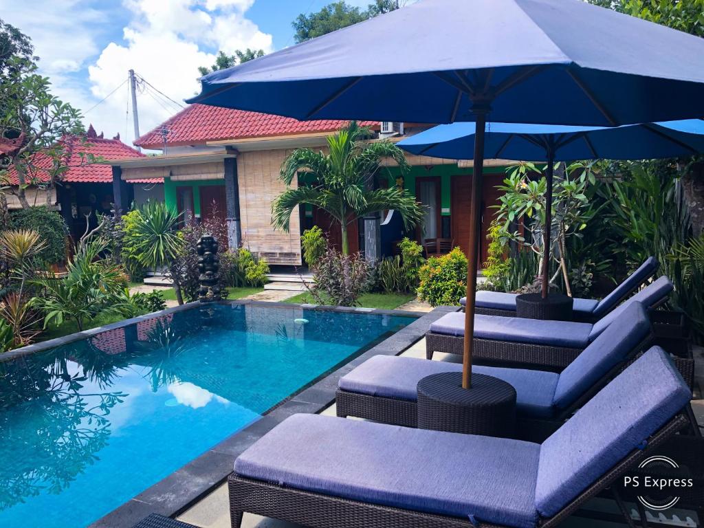 蓝梦岛瓦克图民宿的房屋旁的游泳池配有椅子和遮阳伞