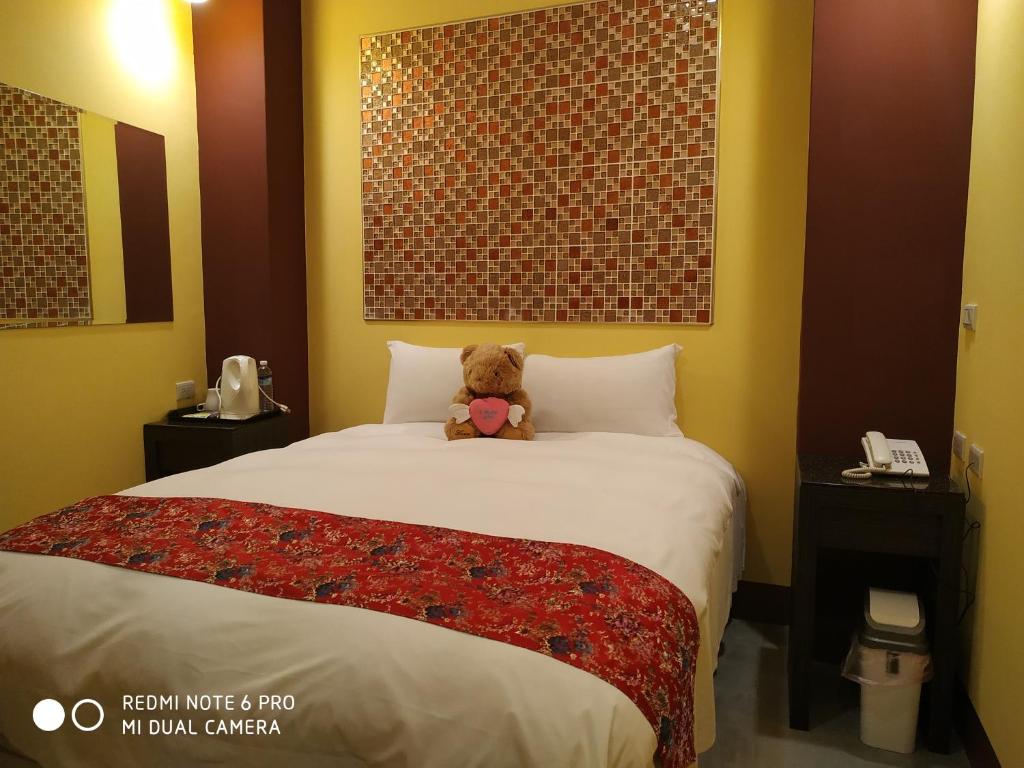 鱼池乡Sun Moon Lake Crown Yu Hotel的坐在酒店房间床上的泰迪熊