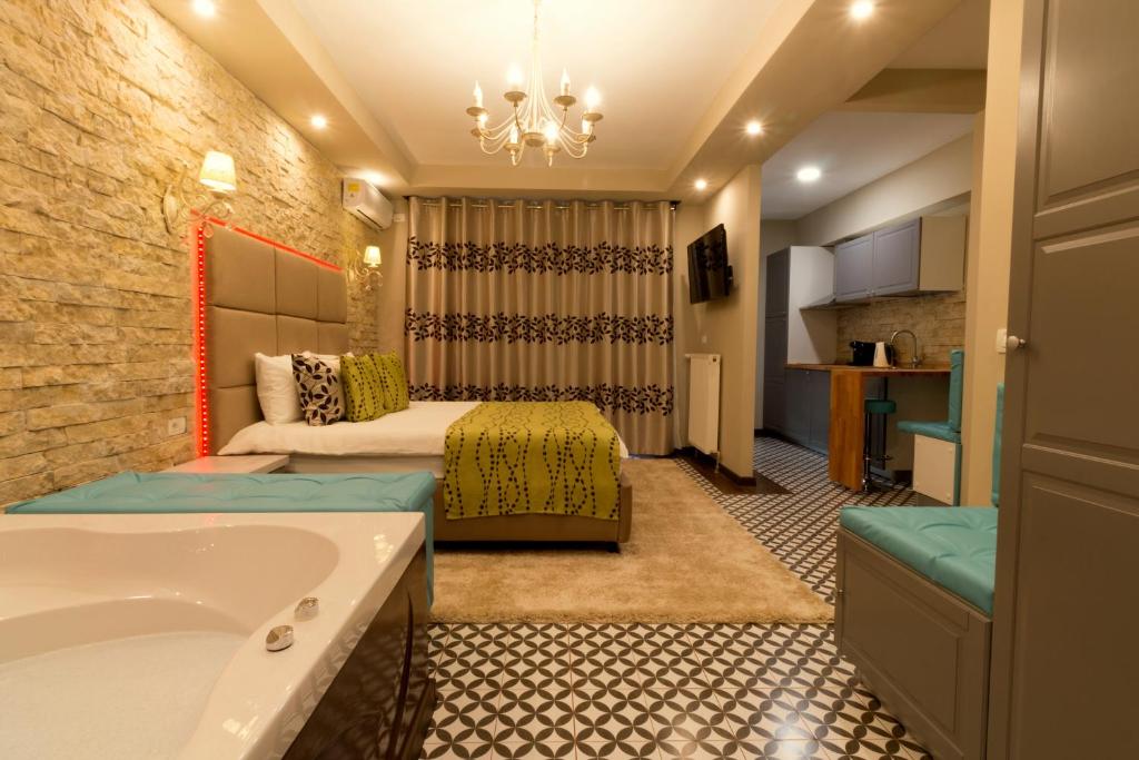 锡纳亚Romantic Jacuzzi Belleview Studio的酒店客房设有两张床和浴缸。