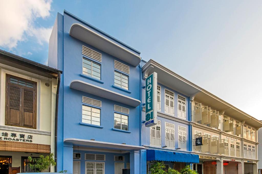 新加坡Hotel 81 Cosy的蓝色的建筑,前面有标志