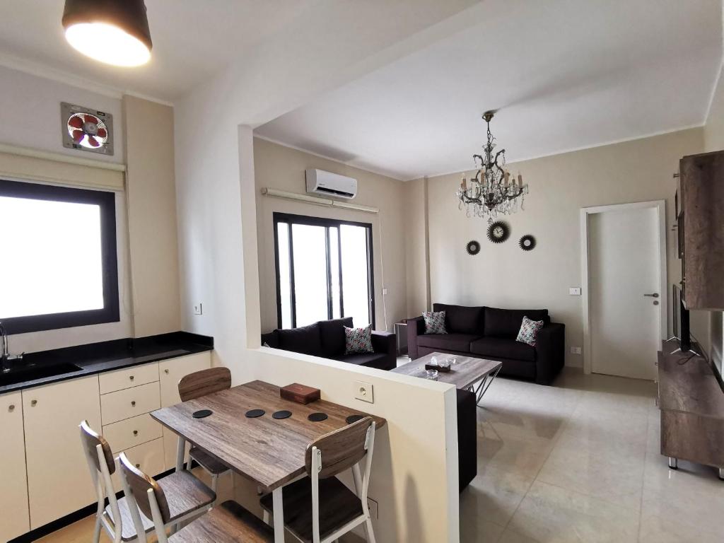 贝鲁特West House Apartments-Mar Mikhael的厨房以及带桌子和沙发的客厅。