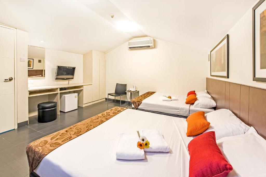 新加坡Hotel 81 Selegie的一间酒店客房,设有两张床和电视
