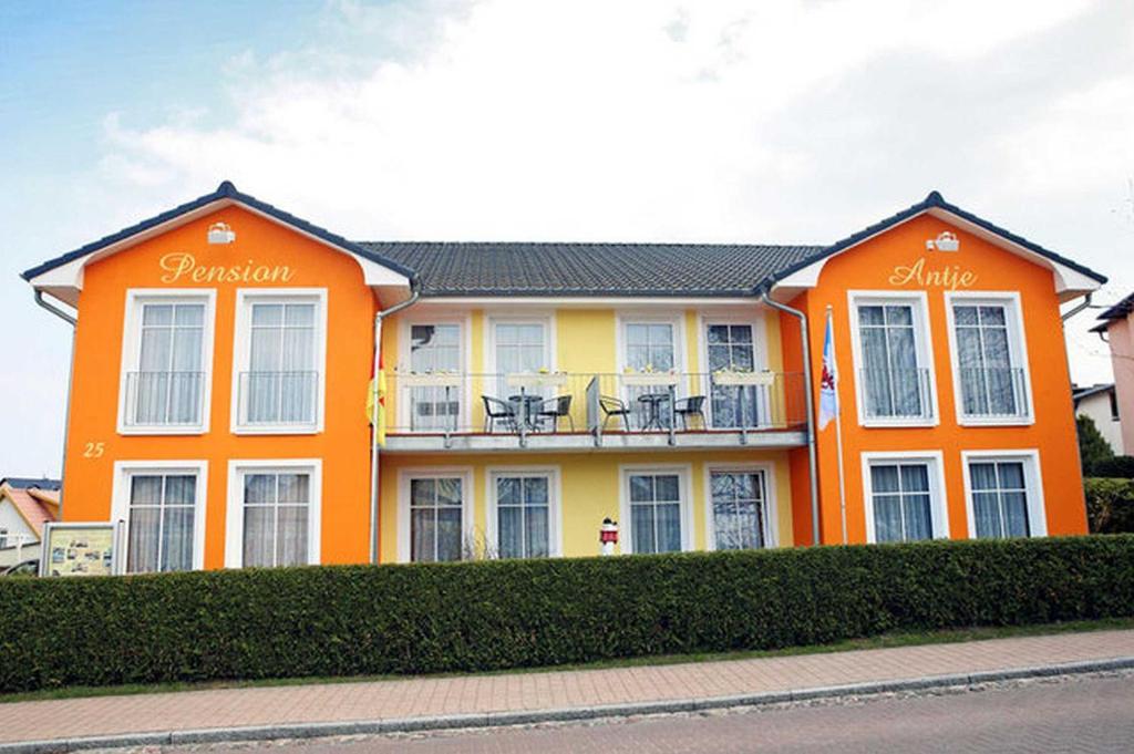 塞巴特阿尔贝克Pension Haus Antje的一座橙色的建筑,阳台上摆放着椅子