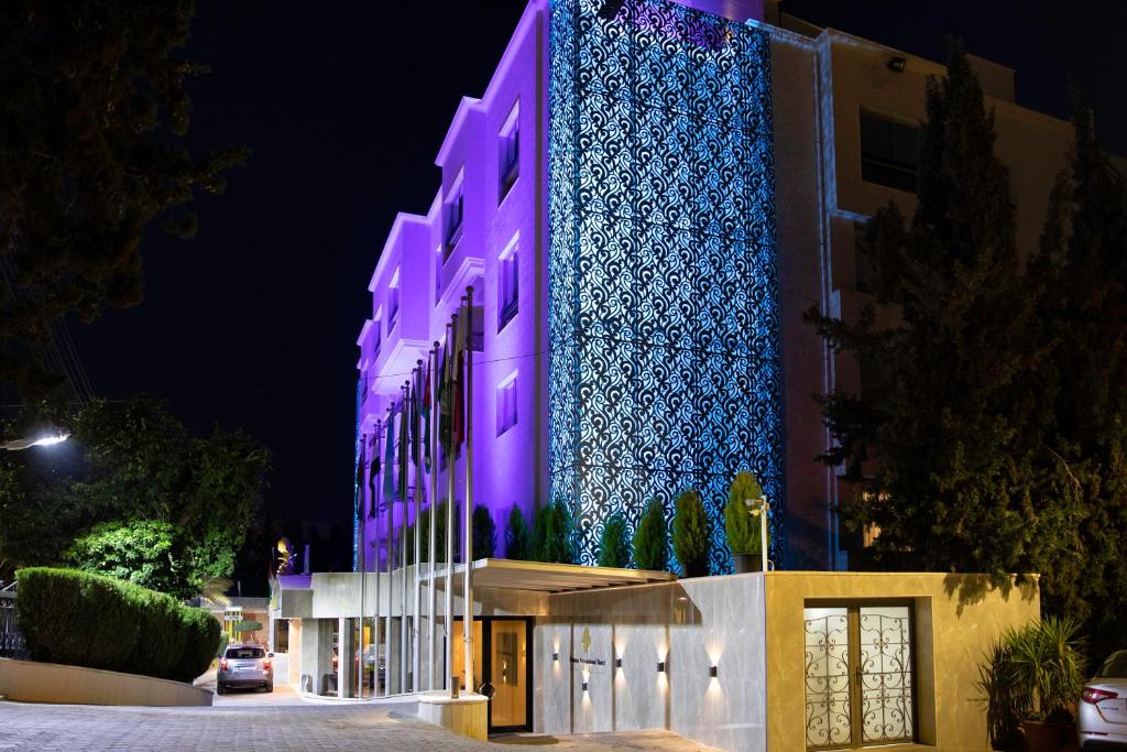 安曼安曼国际酒店的一座晚上用紫色点亮的建筑