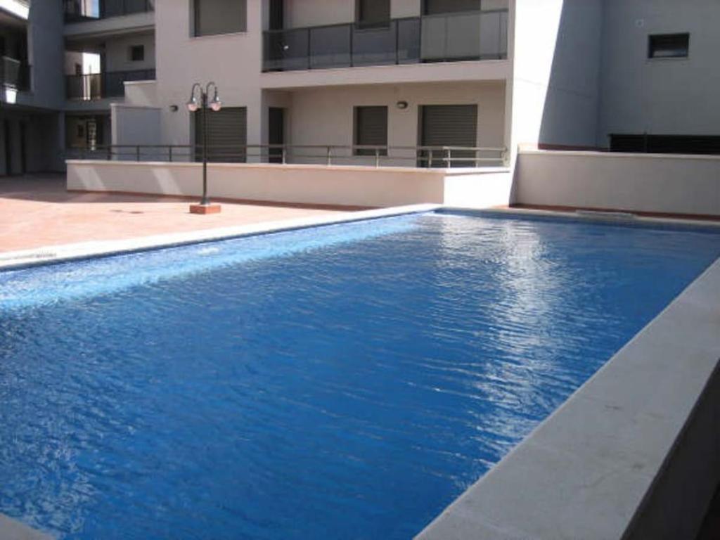 安波拉Precioso apartamento cerca de la playa的大楼前的蓝色游泳池