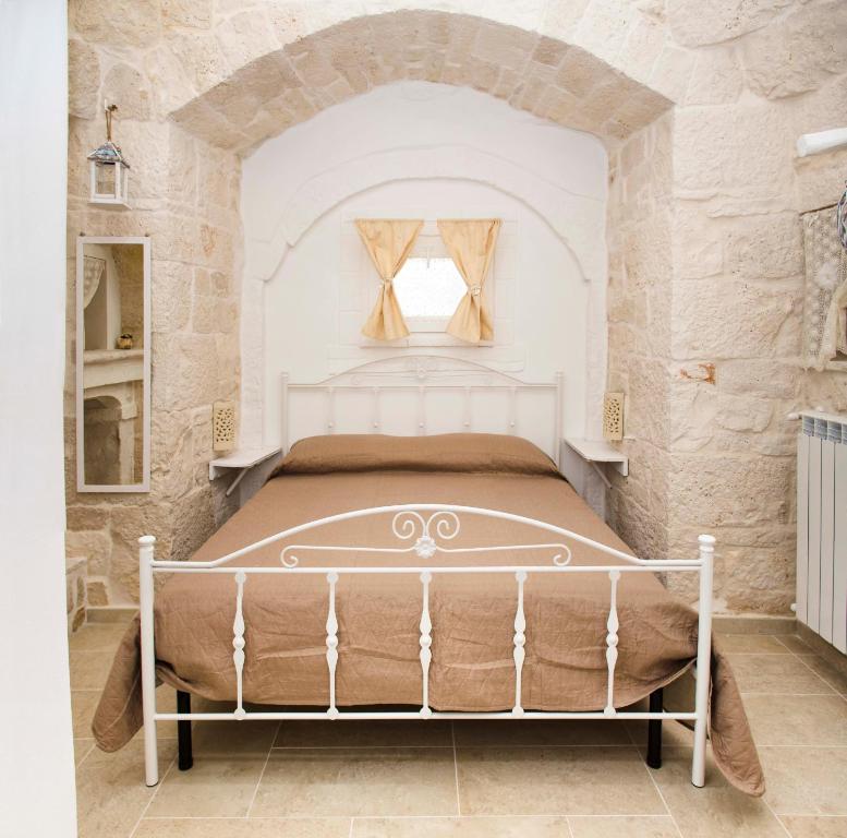 马丁纳弗兰卡Trulli Centenari的卧室配有一张石墙床