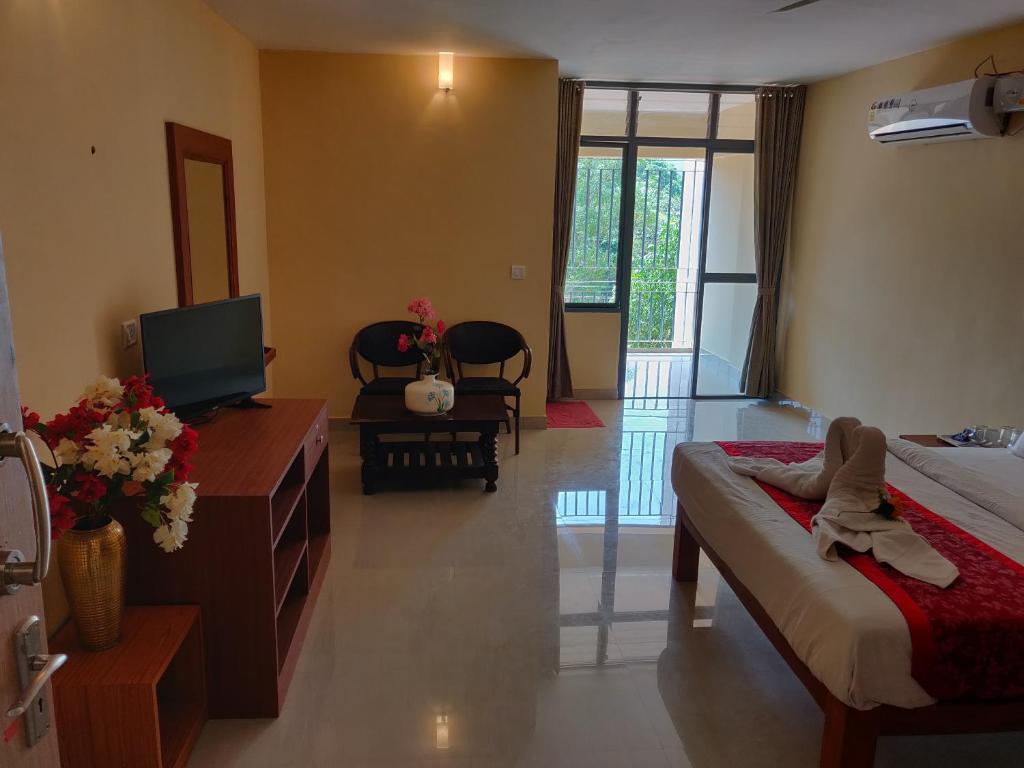 科鲁鲁Paradise Wild Hills Kodachadri的一间酒店客房,配有一张床和一台电视,还有一间客房
