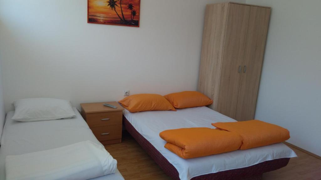 索科矿泉村Studio Milivojevic的小房间设有两张带橙色枕头的床