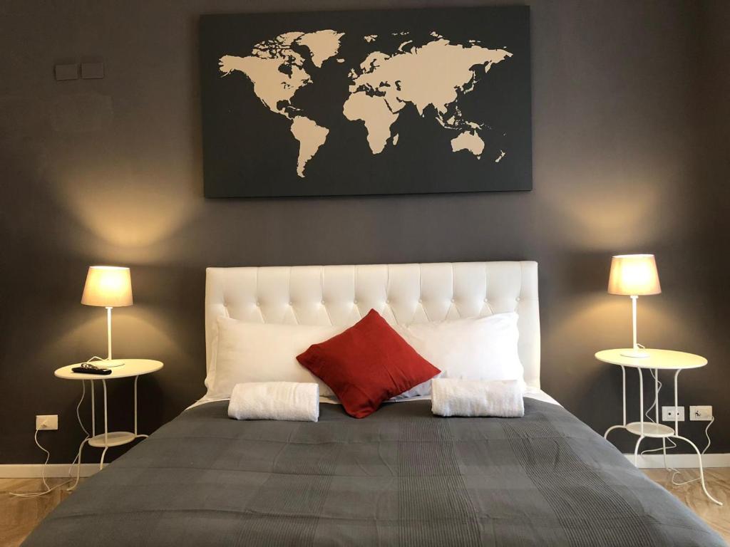 罗马109 SUITES ROMA的一间卧室配有一张大床,墙上挂着世界地图