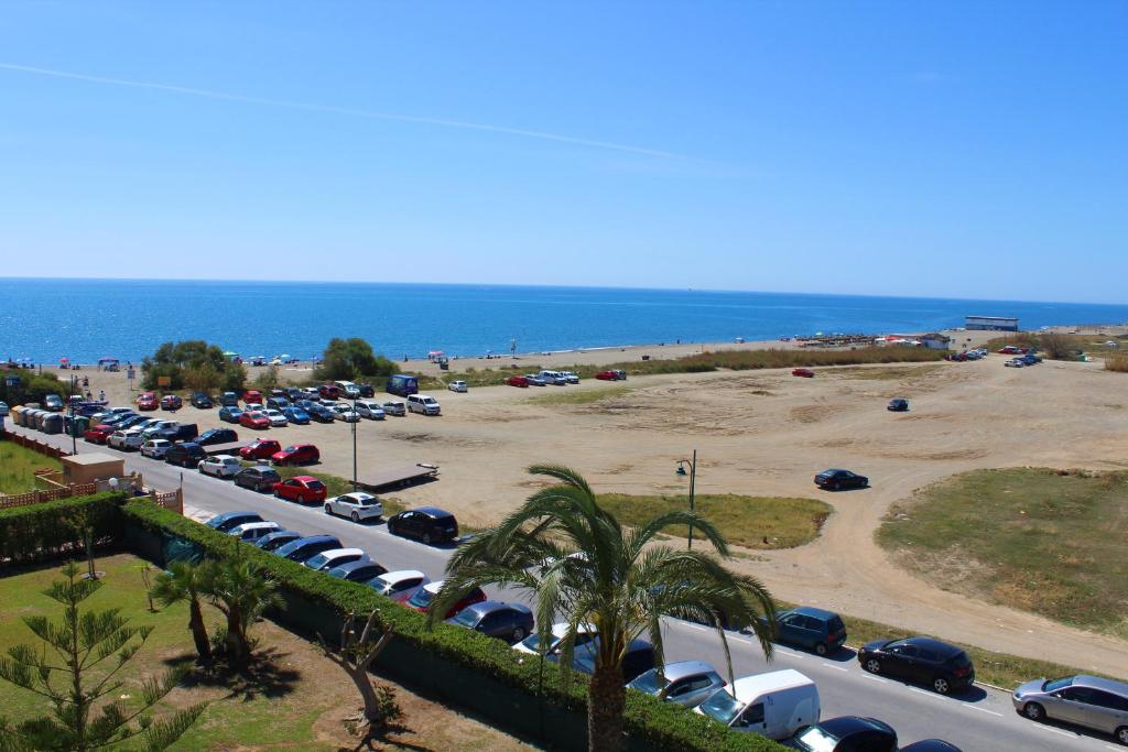马拉加Beach Apartment Guadalmar的海边停车场,有车停放