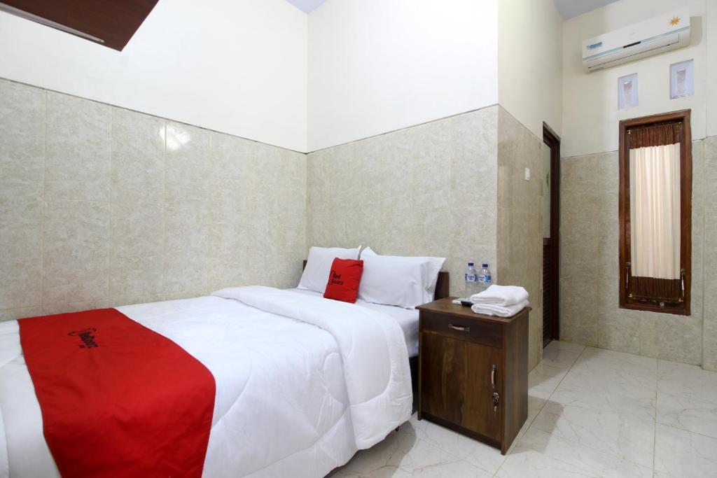 日惹RedDoorz near Museum Gunung Merapi的一间卧室配有一张带红色毯子的大床