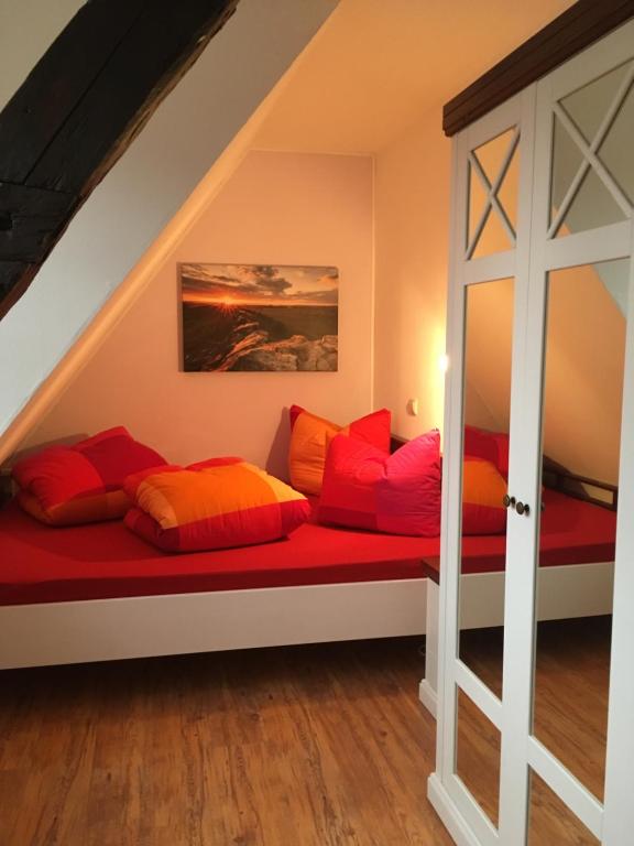 韦尼格罗德Ferienhaus Harzinsel的配有红色和橙色枕头的长凳