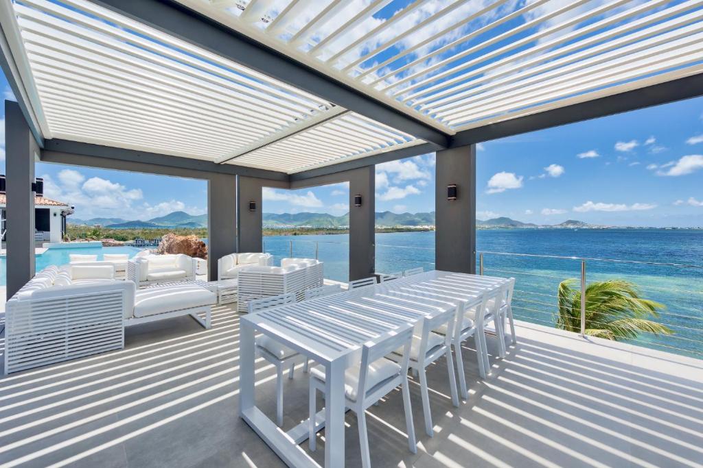 泰尔斯贝斯Dream Villa Terres Basses 564的一个带桌椅的甲板和大海