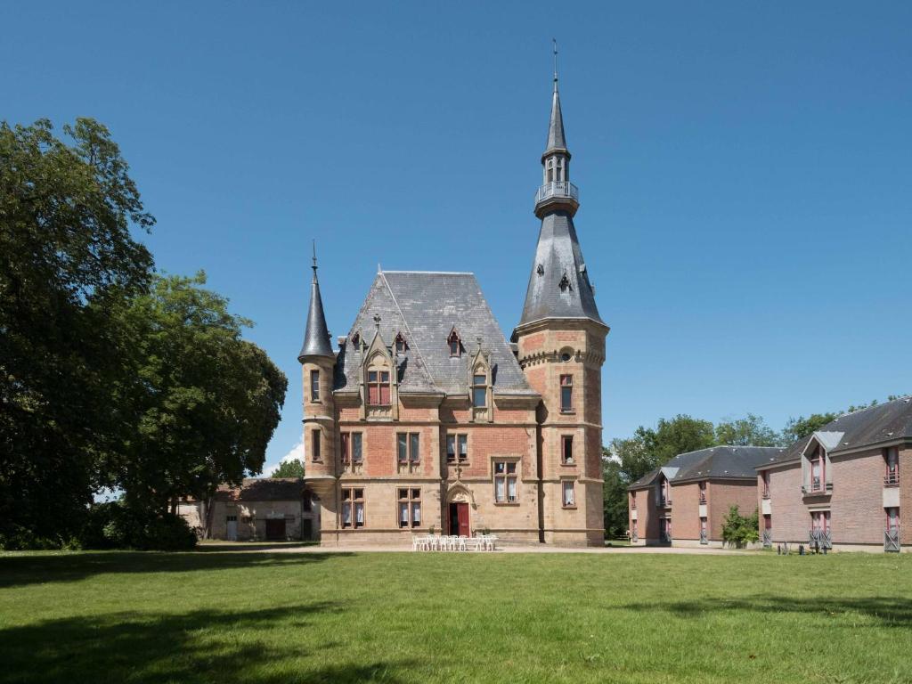 Cosne-dʼAllierChâteau de Petit Bois的一座古老的城堡,在草地上建有一座塔