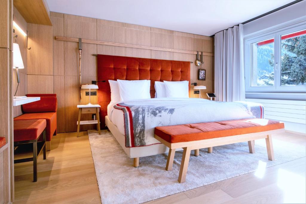 采尔马特Schweizerhof Zermatt - a Small Luxury Hotel的一间卧室设有一张大床和红色床头板