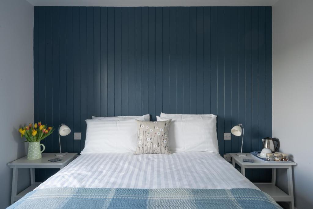 滕比Ty Ffynnon B&B的一间卧室配有一张蓝色墙壁的床