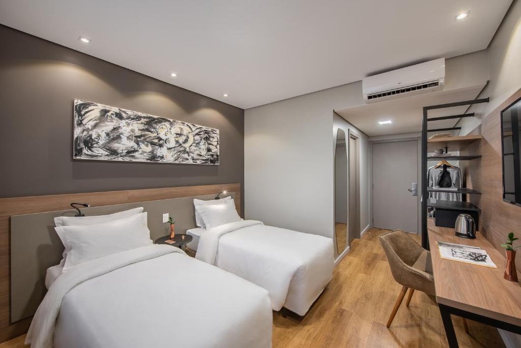 圣利奥波尔杜Intercity Sao Leopoldo的酒店客房配有两张床和一张书桌