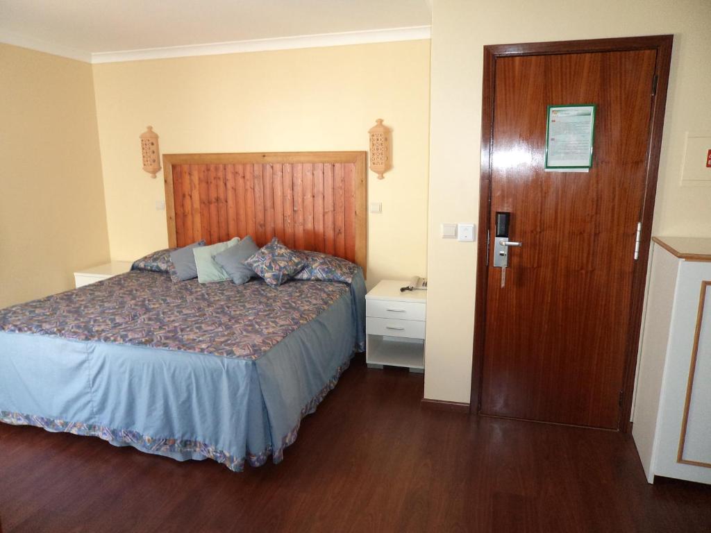 阿尔布费拉VilaBranca的一间卧室配有一张床和一扇木门