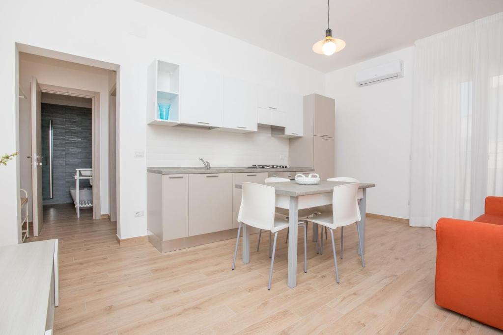 莱韦拉诺Borgo di Leverano, apartment 02的厨房以及带桌椅的用餐室。
