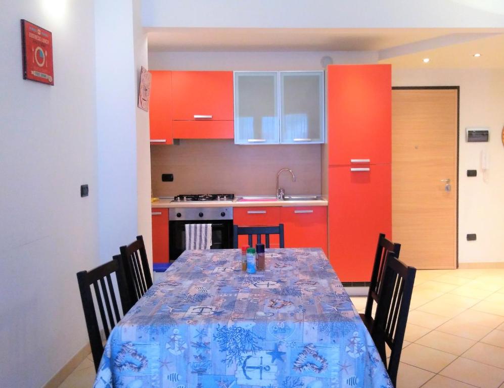 皮特拉利古Appartamento Angela的厨房配有桌椅和红色橱柜