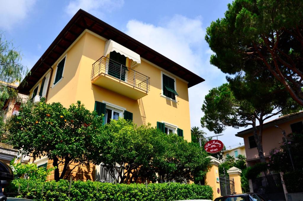 热那亚梦德娜洛坎达别墅酒店的带阳台和树木的黄色建筑