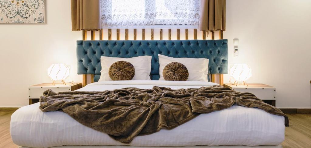 干尼亚Dome Rooms Downtown的一间卧室配有一张大床和蓝色床头板