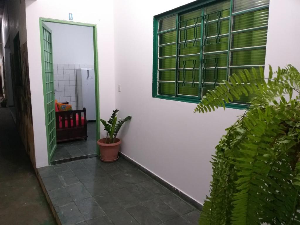 库亚巴Suíte 1, aconchegante, privativa e independente的走廊上设有镜子、窗户和植物