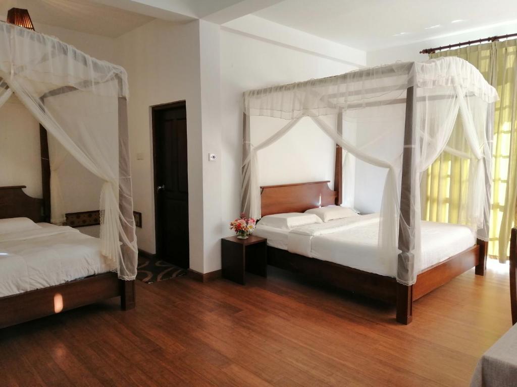 努沃勒埃利耶Melford Nuwaraeliya的铺有木地板的客房内的两张床