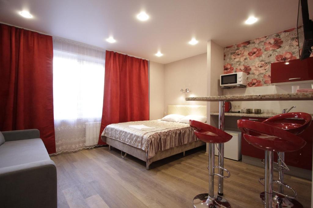 克拉斯诺亚尔斯克Мини-гостиница Австерия на Взлётке的一间卧室配有一张床和红色椅子
