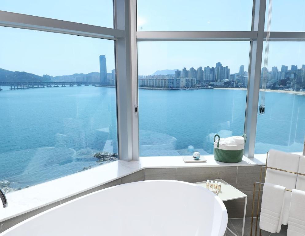 釜山H Avenue Gwanganri Beach的带浴缸的浴室和大窗户