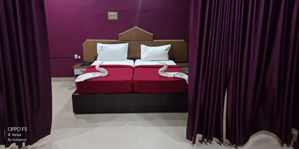 KondottiHotel Nuhman的一间卧室配有红色的床和紫色的墙壁