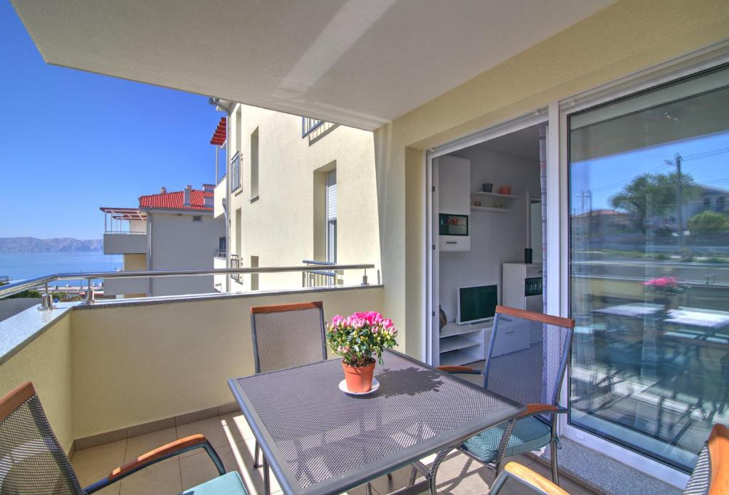 塞尼Apartment Waves-Villa Sunce的阳台配有桌椅和鲜花