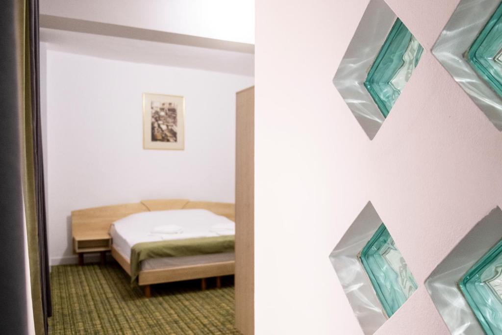 布加勒斯特加布里埃拉旅馆的一间卧室配有一张床和镜子