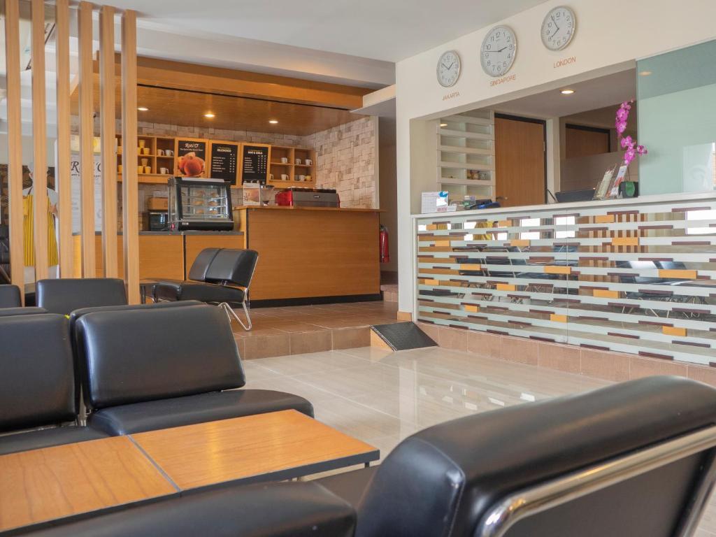 当格浪d'primahotel Airport Jakarta Terminal 1A的一间设有皮椅和柜台的等候室