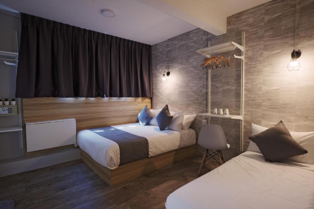 新加坡Q Loft Hotels at Bedok的酒店客房设有两张床和窗户。