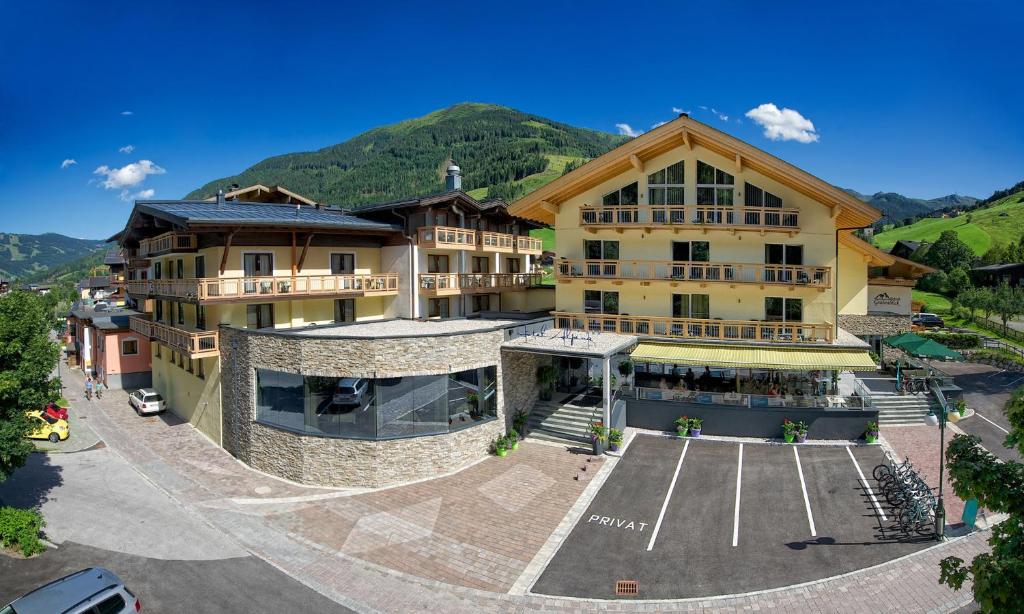 萨尔巴赫Hotel ALPINA的一座大型建筑,前面设有停车场