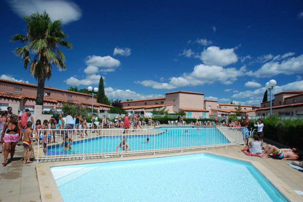 圣西普里安Lagrange Grand Bleu Vacances – Résidence Les Jardins de Neptune的一群人站在游泳池周围