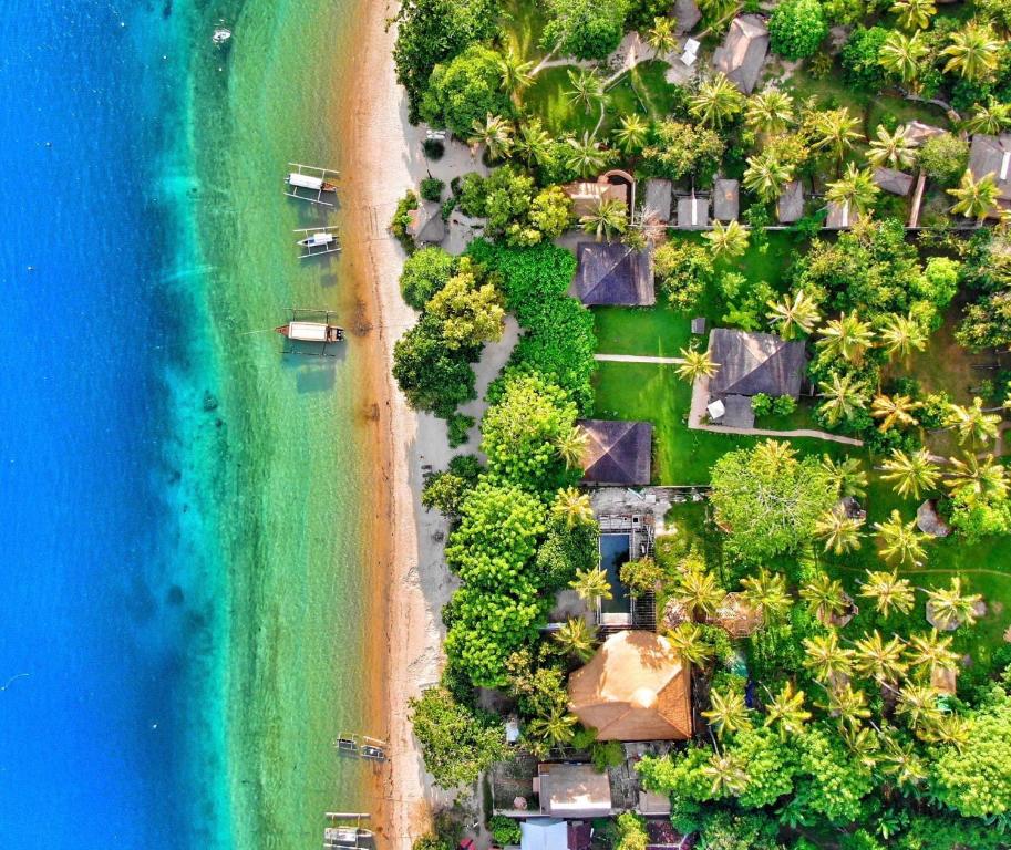 吉利阿萨汉Vayam Boutique Resort Gili Asahan的享有海滩的空中景致,设有房屋和海洋