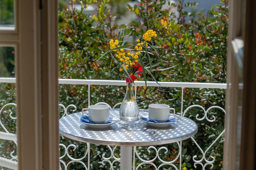 斯派赛斯米墨萨宾馆的一张桌子,上面有两杯,花瓶上有花